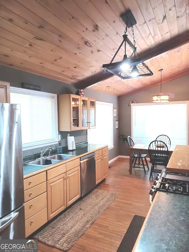 kitchen featuring lofted ceiling with beams, light wood-style flooring, a sink, wood ceiling, and appliances with stainless steel finishes