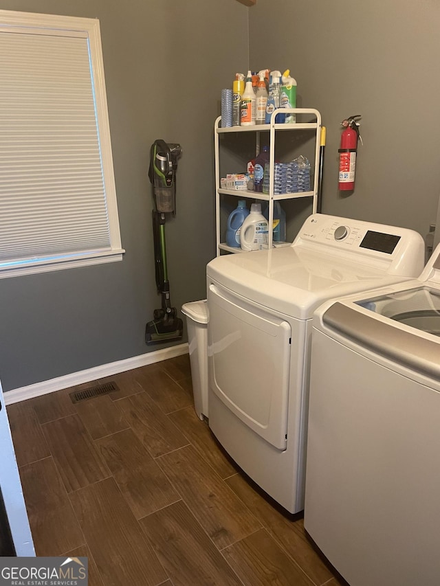 laundry area with laundry area, visible vents, baseboards, washer and dryer, and wood tiled floor