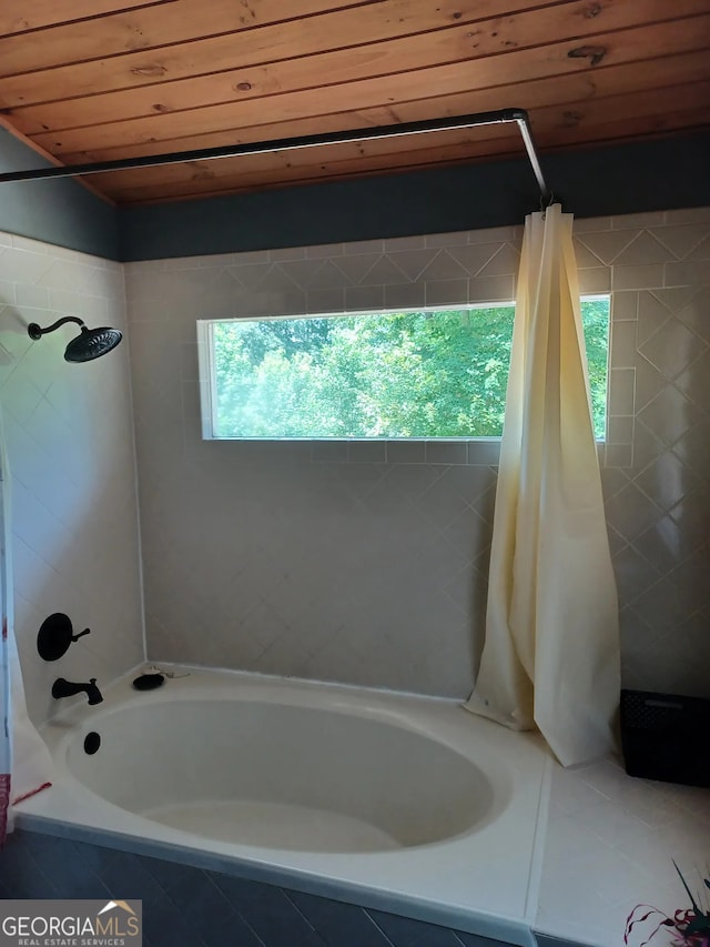 bathroom featuring tiled shower / bath and wood ceiling