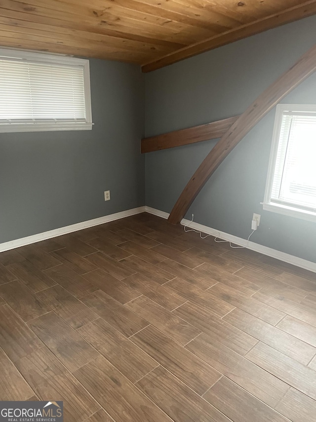 spare room with wood ceiling, baseboards, and wood finished floors