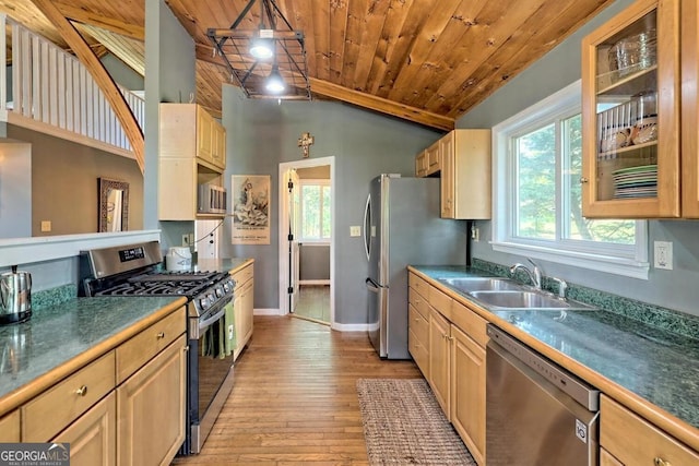 kitchen featuring stainless steel appliances, lofted ceiling, light brown cabinetry, wood ceiling, and a sink