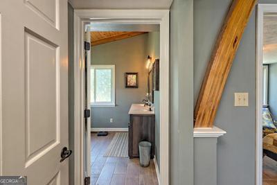 bathroom featuring lofted ceiling, baseboards, wood finished floors, and vanity