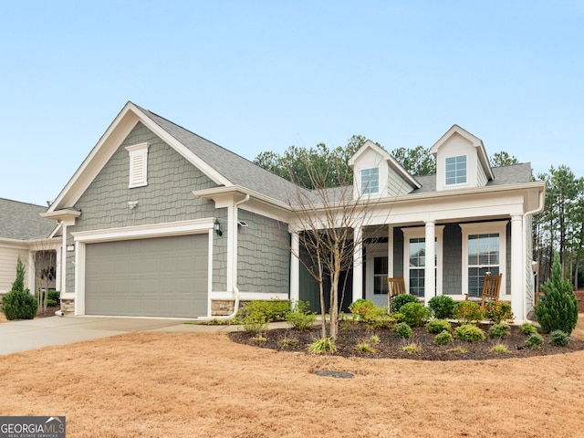 view of front of house with concrete driveway, covered porch, and an attached garage