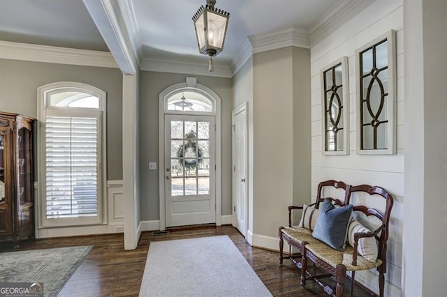 foyer entrance featuring crown molding, dark wood finished floors, and baseboards