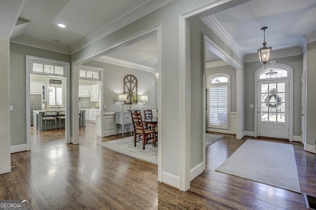 entryway with dark wood-type flooring and crown molding