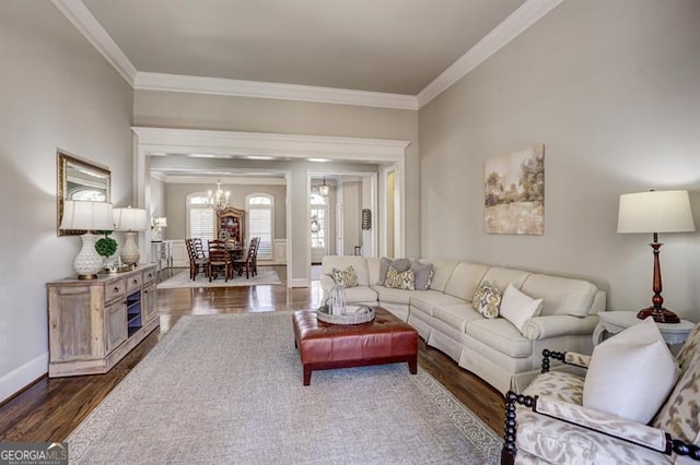 living area featuring a chandelier, ornamental molding, dark wood-style flooring, and baseboards