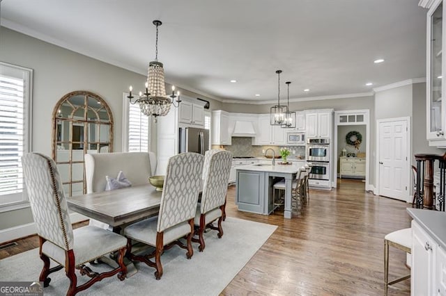 dining space featuring a chandelier, plenty of natural light, and wood finished floors