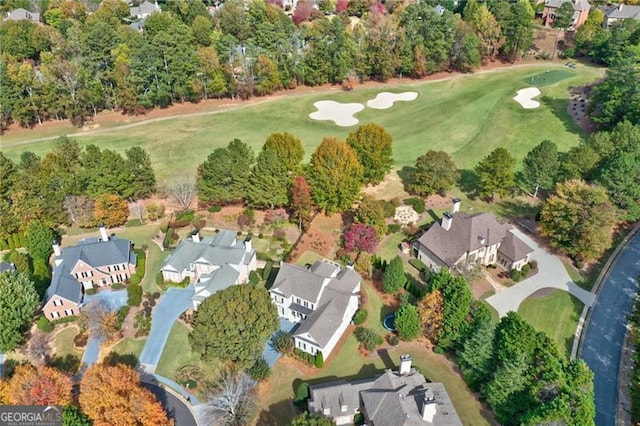 drone / aerial view featuring view of golf course and a residential view