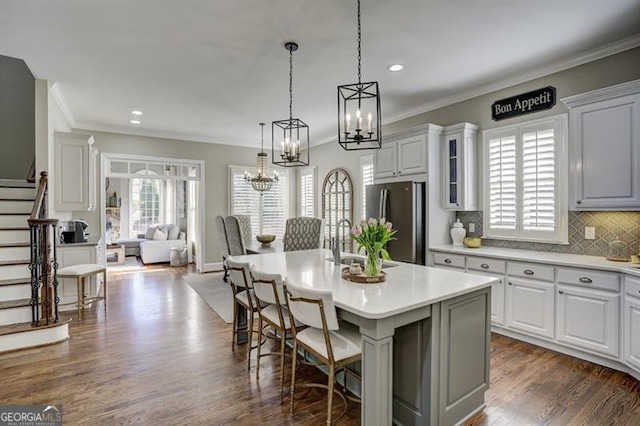 kitchen featuring light countertops, dark wood-style flooring, plenty of natural light, and freestanding refrigerator