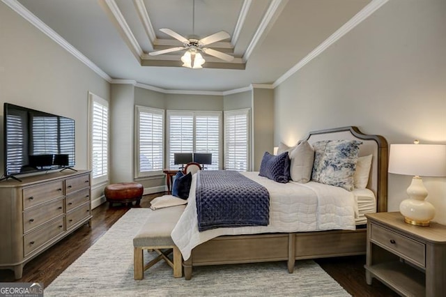 bedroom featuring baseboards, a raised ceiling, a ceiling fan, dark wood-style floors, and crown molding