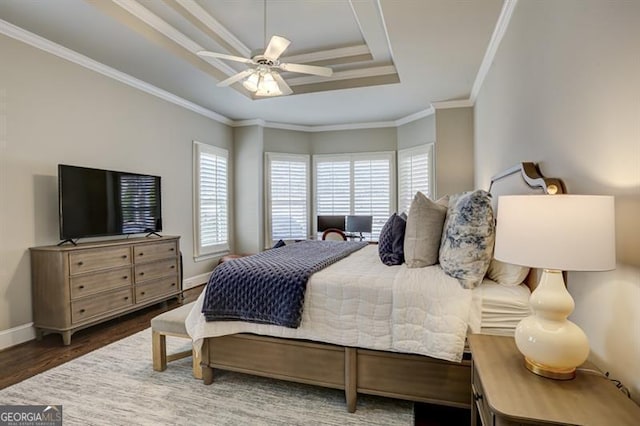 bedroom with a raised ceiling, ornamental molding, a ceiling fan, wood finished floors, and baseboards