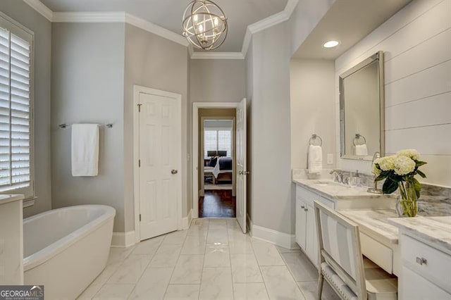 ensuite bathroom with ornamental molding, a soaking tub, vanity, and baseboards