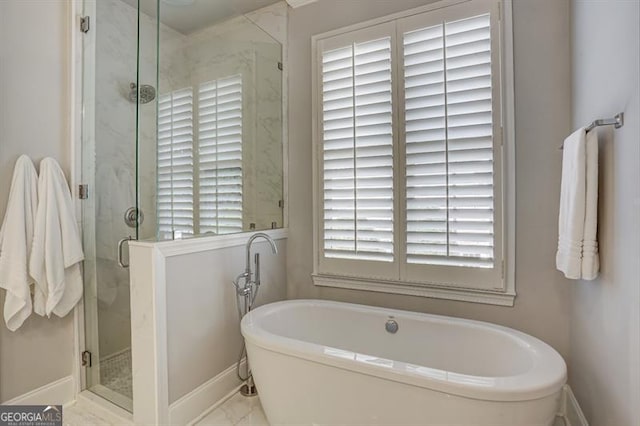 full bath with a soaking tub, baseboards, a marble finish shower, and marble finish floor