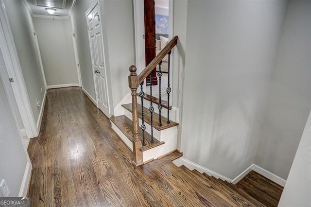 stairway with attic access, baseboards, and wood finished floors