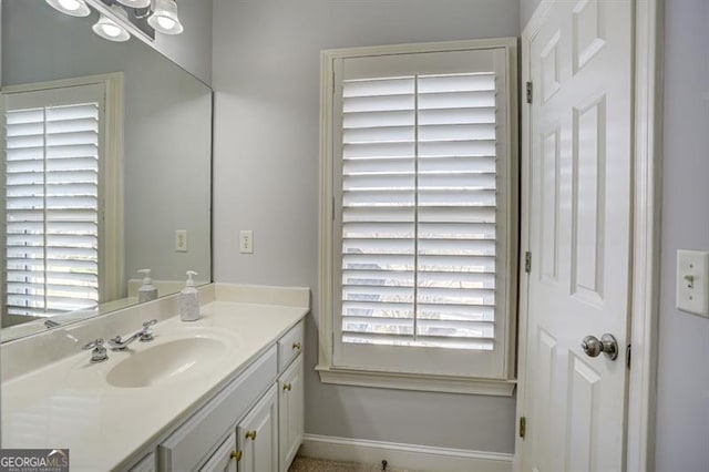 bathroom featuring a healthy amount of sunlight, vanity, and baseboards