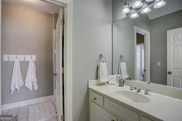 bathroom with baseboards, vanity, and tile patterned floors