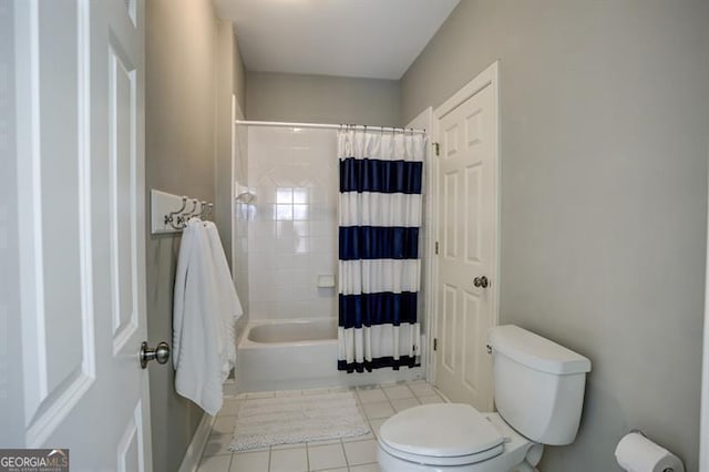 bathroom featuring shower / bathtub combination with curtain, toilet, and tile patterned floors