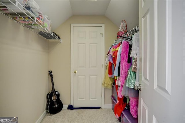 walk in closet featuring carpet flooring and vaulted ceiling