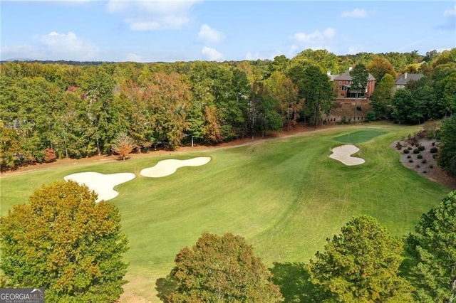 aerial view with view of golf course and a forest view