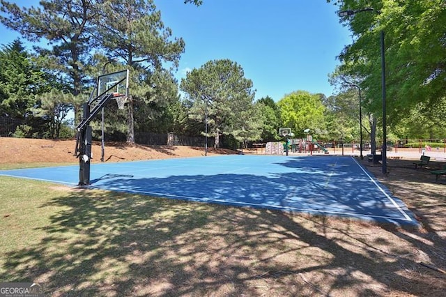 view of basketball court with community basketball court, fence, and playground community