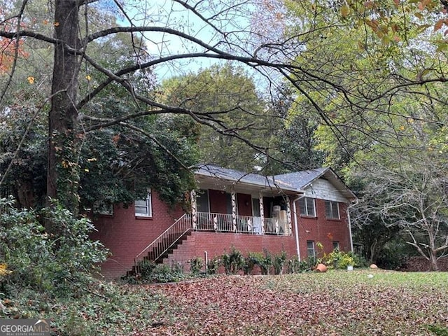 view of front facade featuring covered porch and brick siding