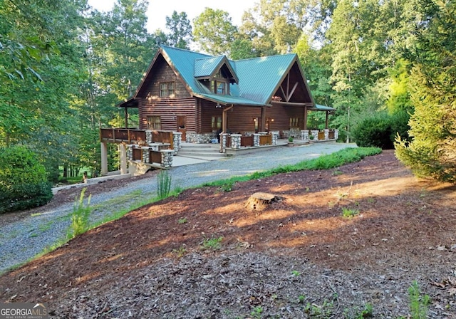 view of front of property featuring stone siding and metal roof