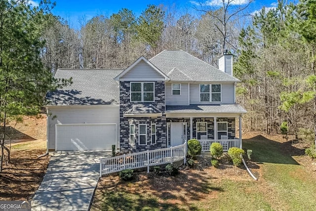 view of front of property with a garage, concrete driveway, stone siding, covered porch, and a front lawn