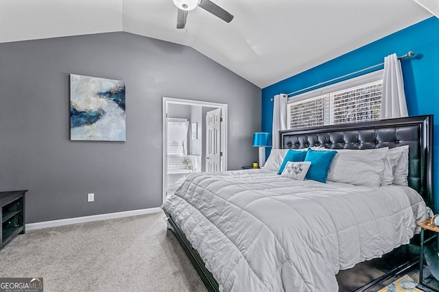 carpeted bedroom featuring lofted ceiling, ensuite bath, ceiling fan, and baseboards