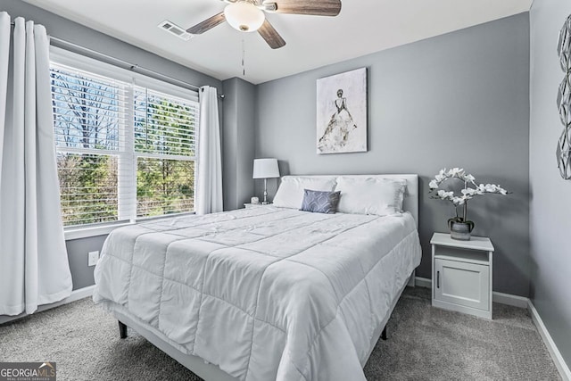 bedroom featuring a ceiling fan, visible vents, baseboards, and carpet flooring