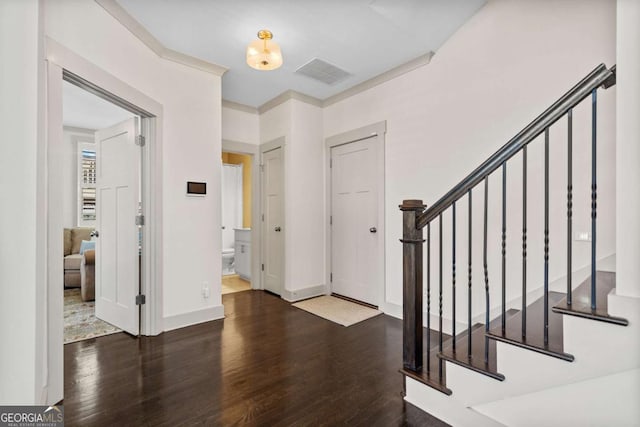 foyer entrance with stairs, visible vents, baseboards, and wood finished floors