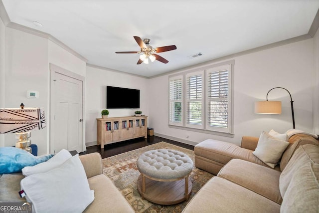 living area with baseboards, visible vents, a ceiling fan, ornamental molding, and wood finished floors