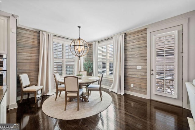 203 Hubbard Rd, Woodstock, GA 30188 - dining area with baseboards, wood walls, a notable chandelier, and dark wood-style floors