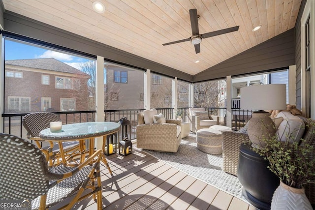 sunroom / solarium with lofted ceiling, wooden ceiling, and ceiling fan