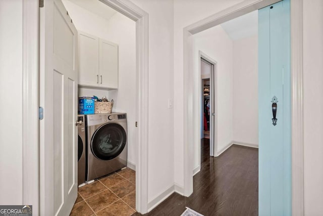 laundry area with washing machine and dryer, baseboards, and dark wood finished floors