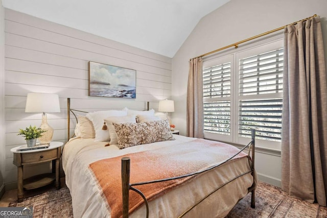 bedroom with lofted ceiling, multiple windows, and baseboards