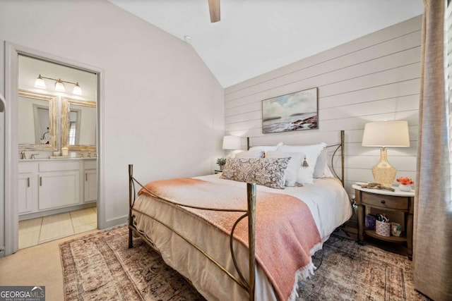 bedroom featuring light carpet, a ceiling fan, lofted ceiling, ensuite bath, and light tile patterned flooring