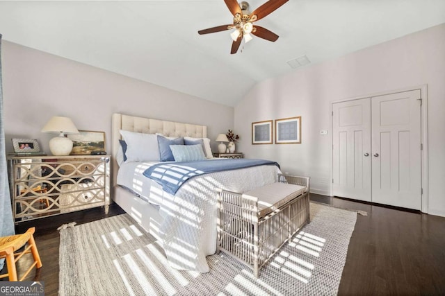 bedroom featuring a ceiling fan, visible vents, vaulted ceiling, and wood finished floors