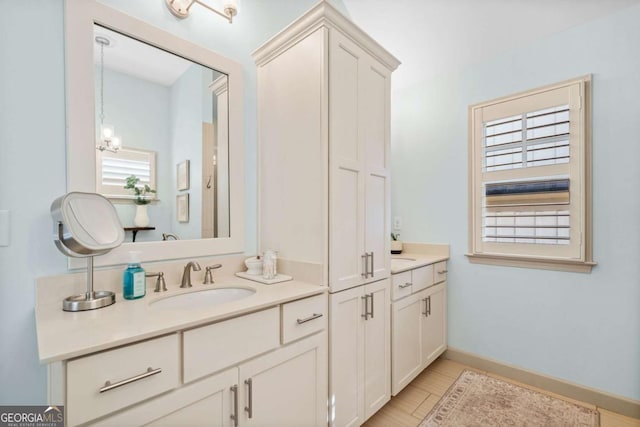 full bathroom featuring wood finished floors, vanity, baseboards, and an inviting chandelier