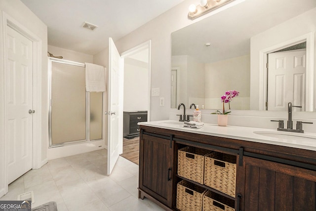 bathroom featuring a stall shower, visible vents, and a sink