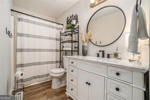 full bathroom featuring toilet, curtained shower, wood finished floors, and vanity