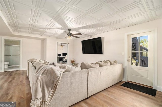 living room featuring an ornate ceiling, ceiling fan, and light wood finished floors