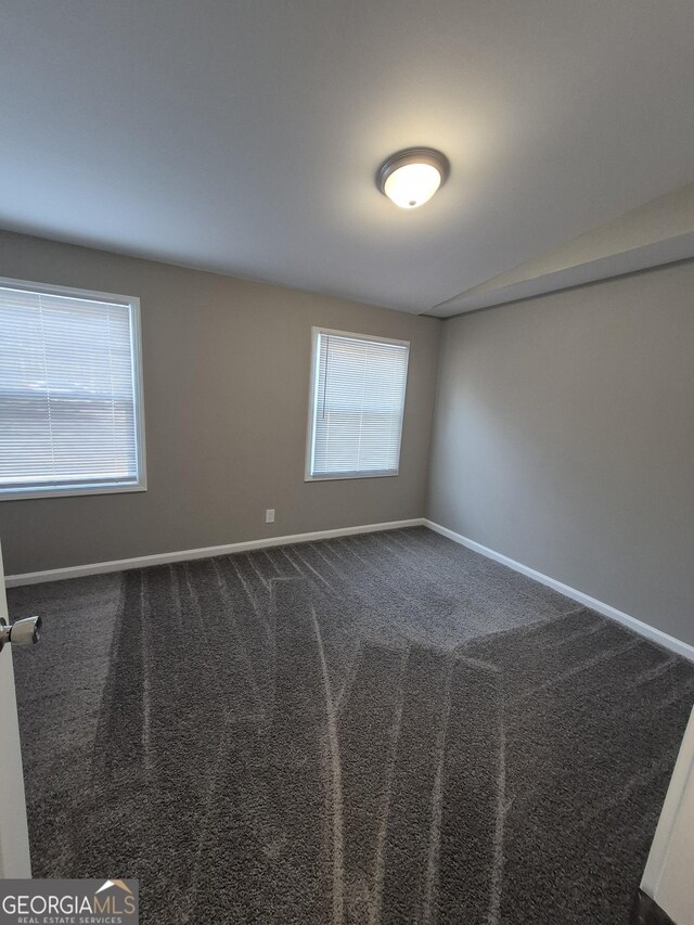 additional living space with dark wood-type flooring, a textured ceiling, visible vents, lofted ceiling, and baseboards
