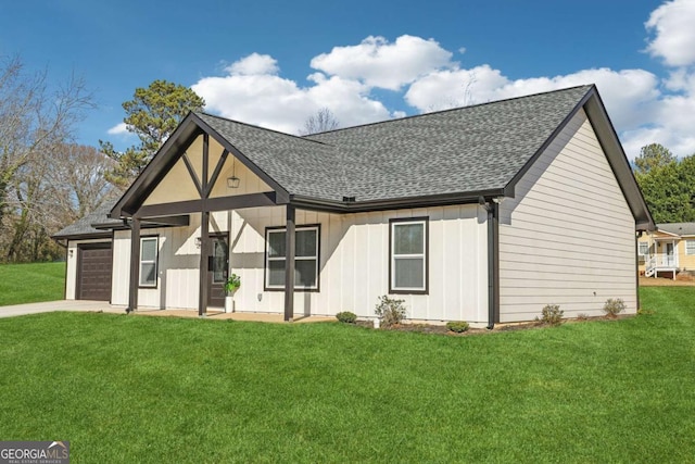 view of front of property featuring a garage, driveway, a front lawn, and roof with shingles