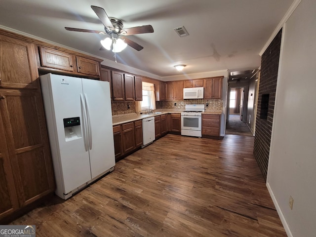 kitchen with white appliances, dark wood-style flooring, a sink, and backsplash