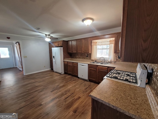 kitchen featuring white appliances, ornamental molding, a wealth of natural light, and a sink