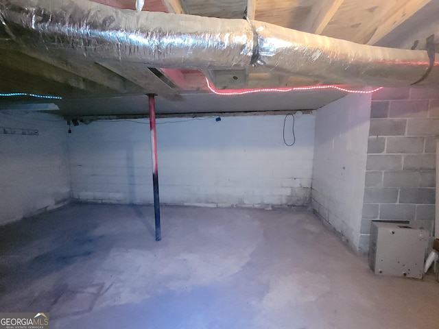 unfinished basement featuring concrete block wall