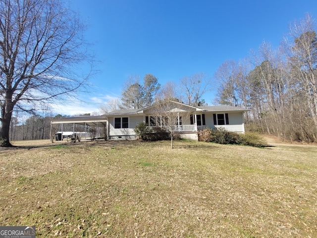 view of front of house featuring a carport, covered porch, and a front lawn