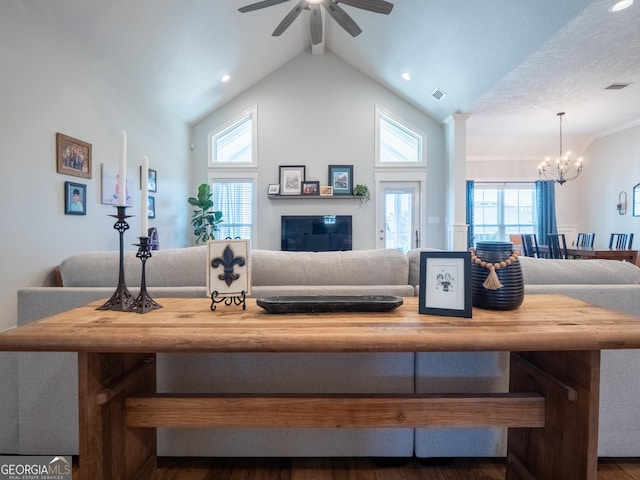 living area with high vaulted ceiling, visible vents, beam ceiling, and ceiling fan with notable chandelier