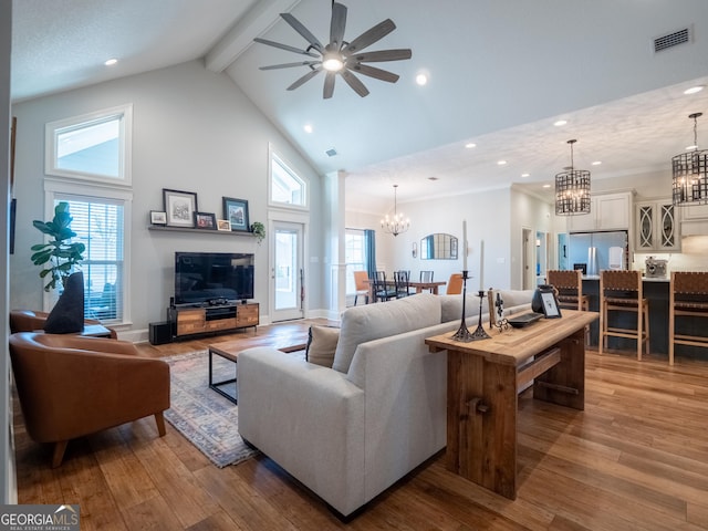 living area with high vaulted ceiling, visible vents, beamed ceiling, and hardwood / wood-style flooring