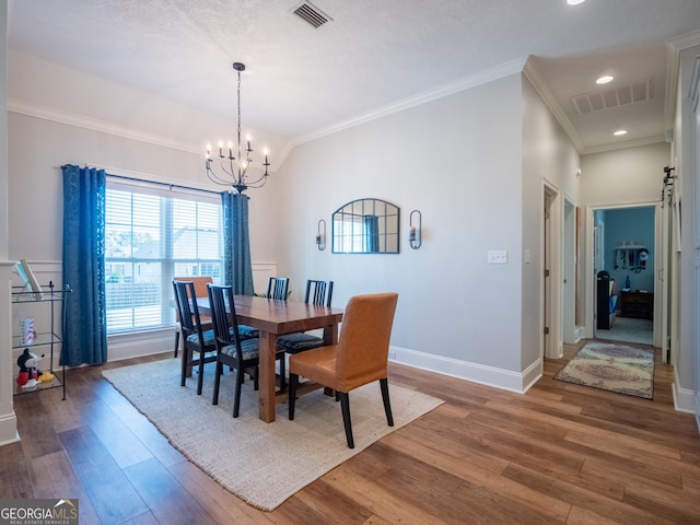 dining space featuring a chandelier, wood finished floors, and visible vents